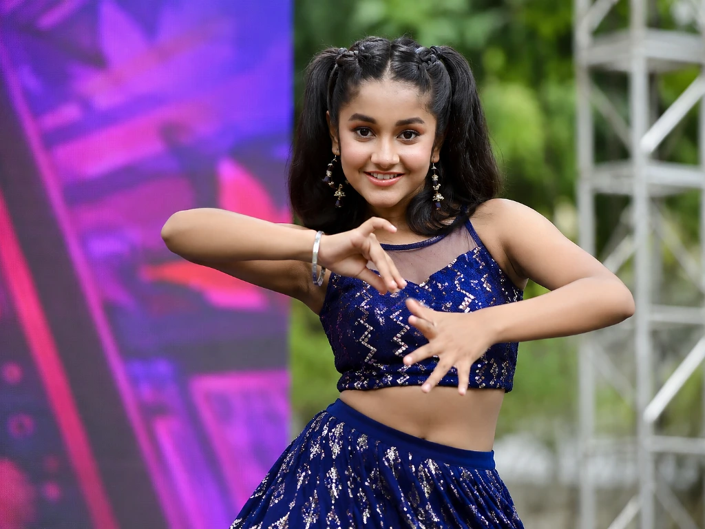 Ridhi Rajak performing a dance on an outdoor stage in a blue sequined outfit