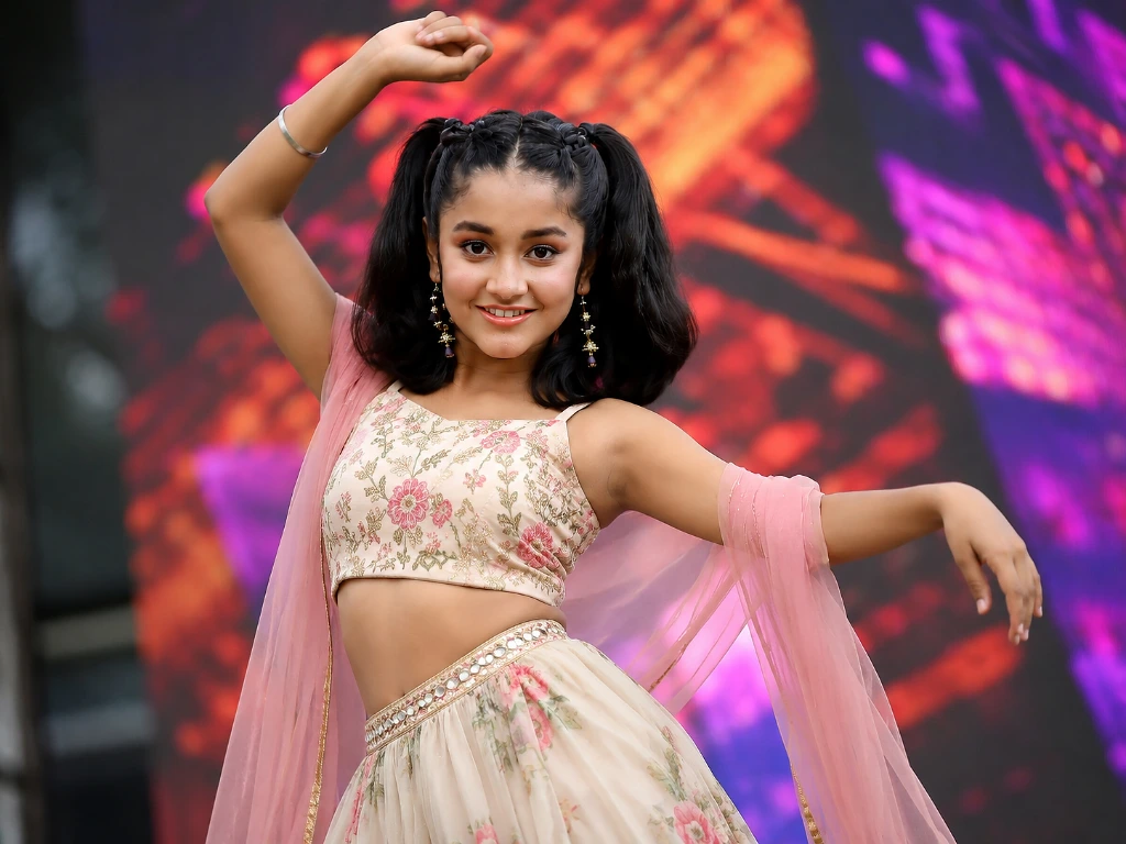 Ridhi Rajak performing a dance on stage in a pink floral outfit